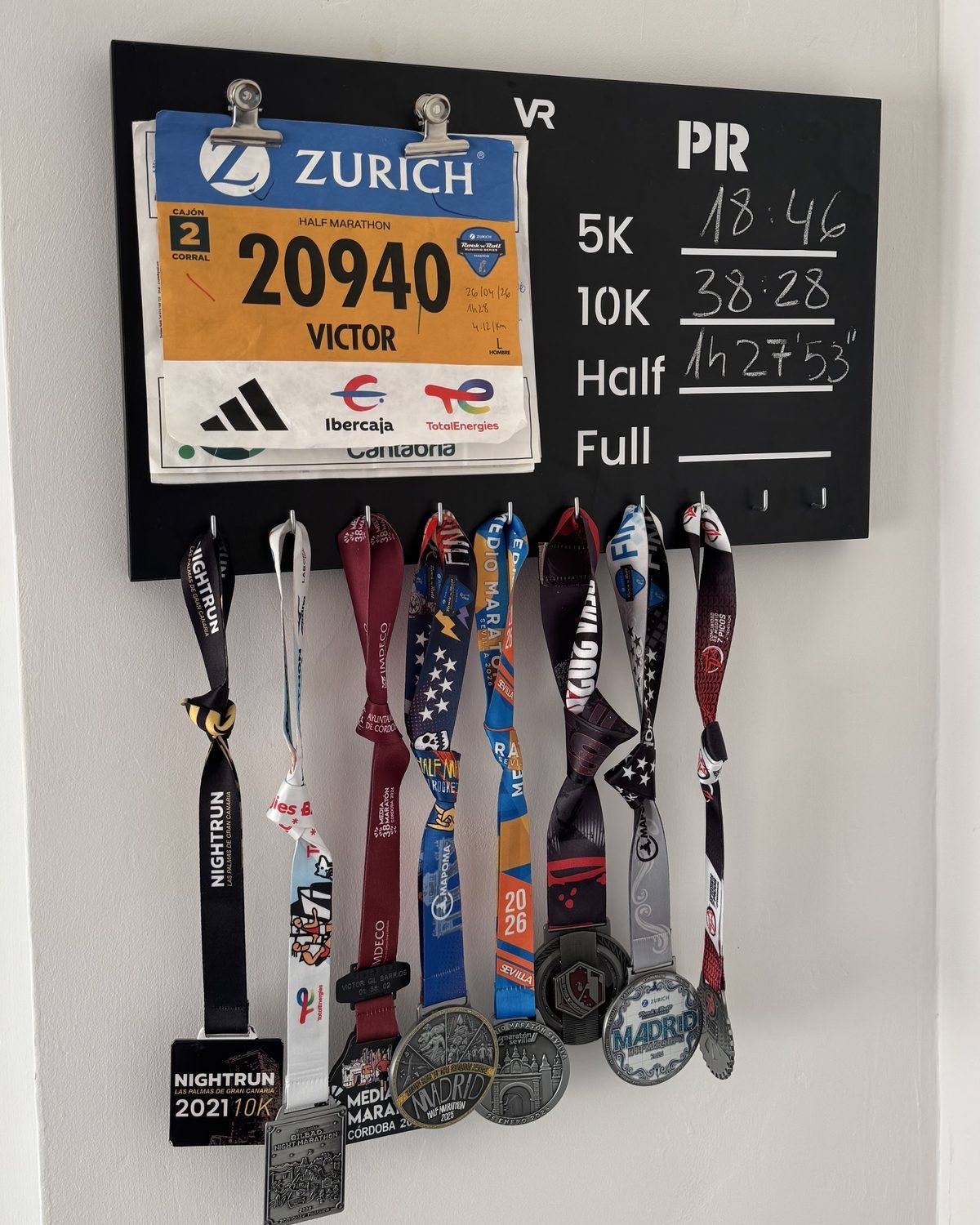 Dorsal sujeto con las pinzas del medallero Viccora, con medallas colgadas debajo