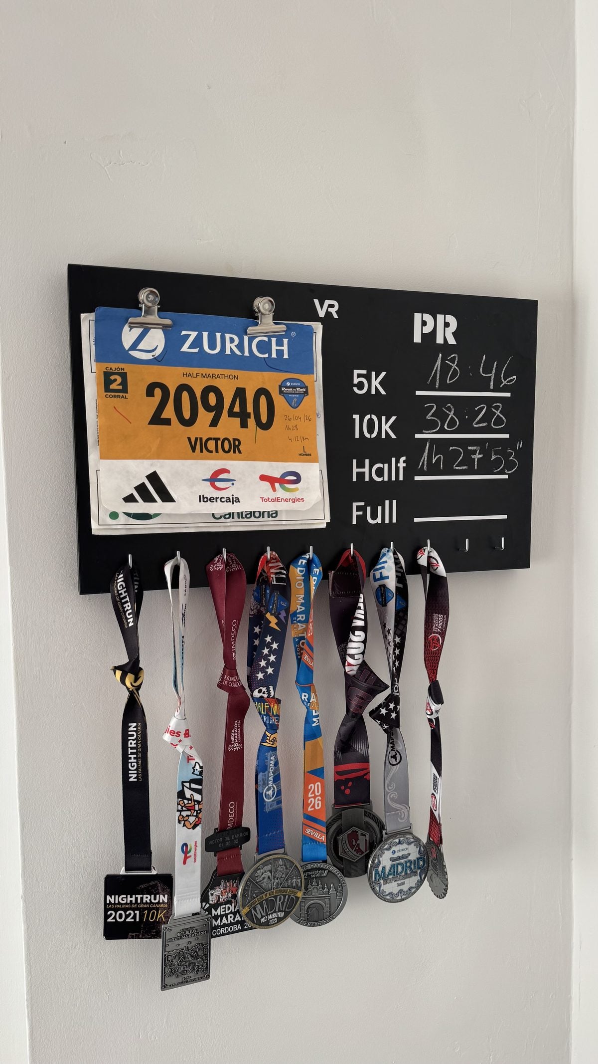 Medallero Viccora colgado en casa con medallas y un dorsal