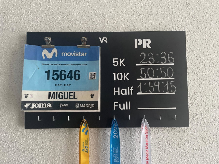 Medallero Viccora de Miguel con un dorsal, tres medallas y sus marcas apuntadas