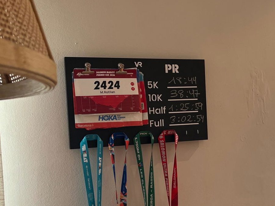 Medallero Viccora de Marc con su dorsal, sus marcas a tiza y cuatro medallas colgadas